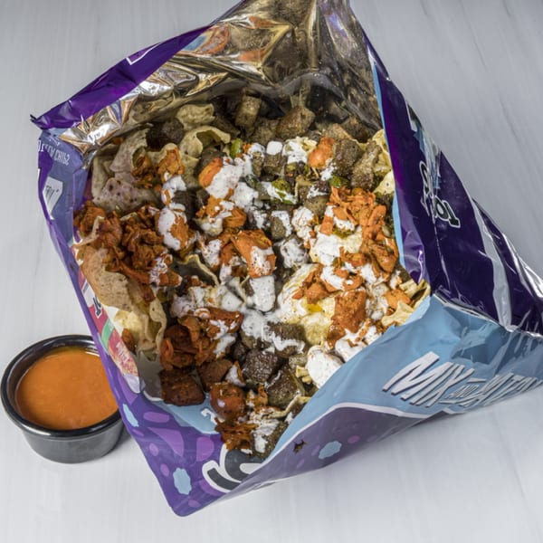 Blazing Hot Halal Grill's loaded chips with chicken, sauce, and a side of dipping sauce.