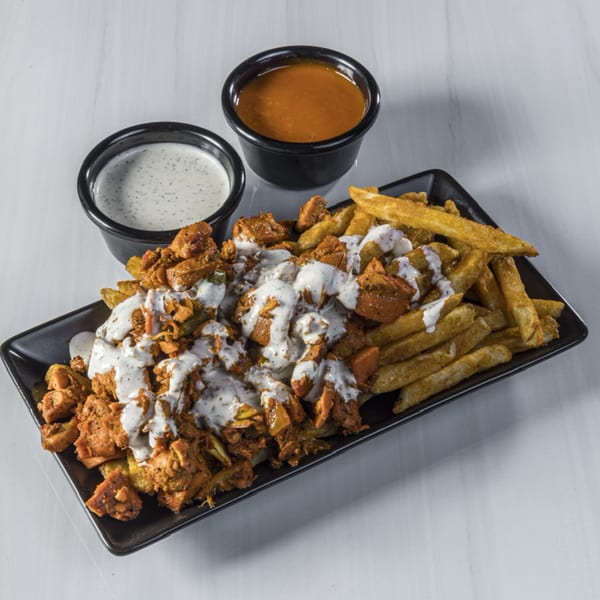 Halal chicken and fries drizzled with white sauce, served with two dipping sauces.