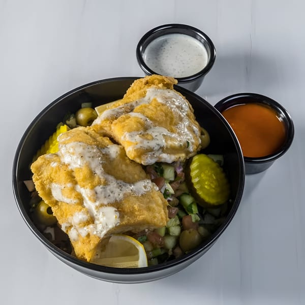 Blazing Hot Halal Grill's fried fish over rice with salad, pickles, lemon, and two sauces.
